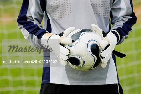 soccer goalie gloves holding a ball