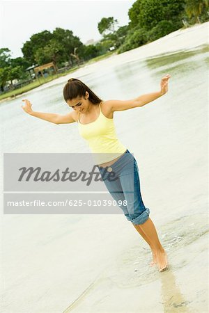 Girl standing in a lake with her arms outstretched