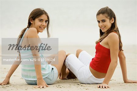 Portrait of two girls sitting on the beach