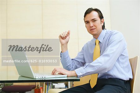 Portrait of a businessman using a laptop in an office