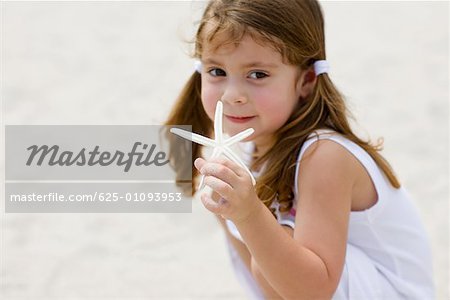 Portrait of a girl holding a starfish