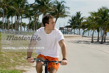 Close-up of a young man cycling on the road