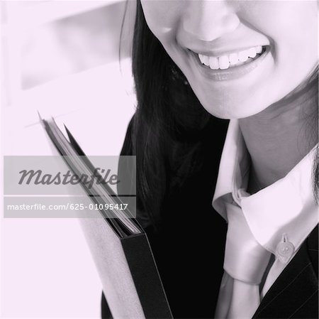 Close-up of a businesswoman holding a file and smiling