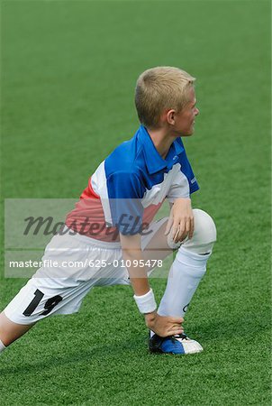 Soccer player stretching in a soccer field