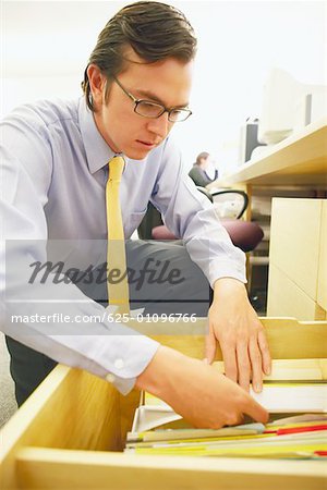 Close-up of a businessman searching for a file in drawer