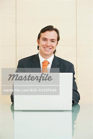 Portrait of a businessman sitting in front of a laptop