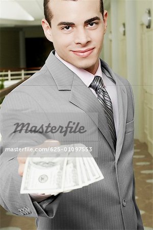 Portrait of a businessman showing American paper currency