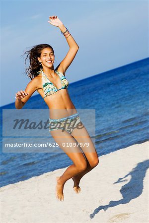 Teenager, girl in blue swimming suit on the beach Stock Photo