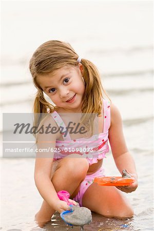 Portrait of a girl playing with toys on the beach