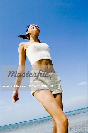 Side profile of a mid adult man holding a fishing rod on the beach