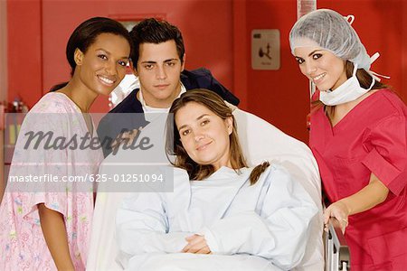 Two female doctors and a male doctor pushing a female patient on a hospital gurney
