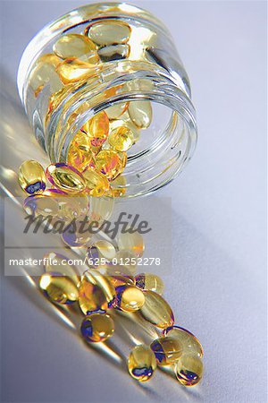 Close-up of vitamin e capsules spilling from a jar