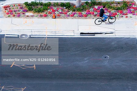 High angle view of a man riding a bicycle on sidewalk