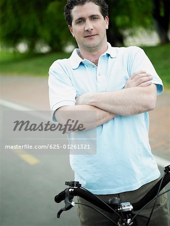 Portrait of a mid adult man standing with a bicycle