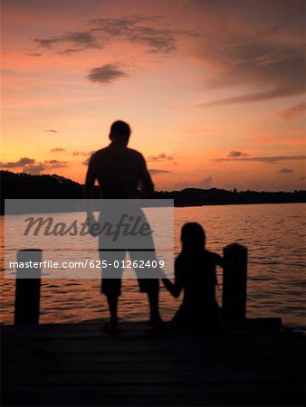 Silhouette of a man and a woman on a pier