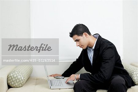 Businessman using a laptop on a couch