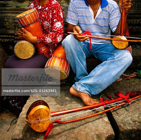 Close-up of two musicians at a temple, Ta Prohm Temple, Angkor, Siem Reap, Cambodia