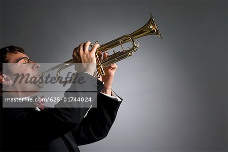 Side profile of a musician playing a trumpet