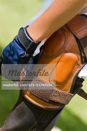 Close-up of a person tying a riding boot