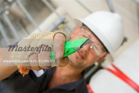 Close-up of a male construction worker holding a cutting tool