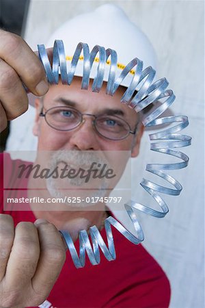 Portrait of a male construction worker folding a metal spring and smiling