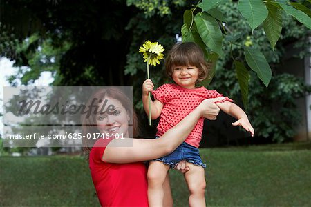 Portrait of a young woman picking up her daughter and smiling