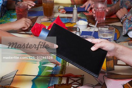 Close-up of a person's hand paying bill by credit card in a restaurant