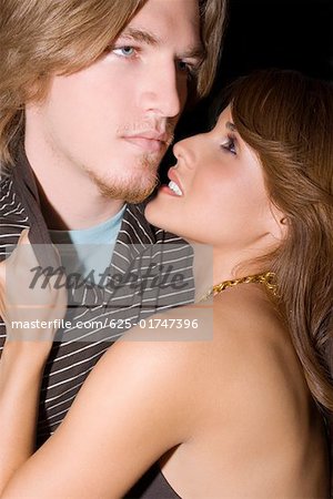 Side profile of a young woman holding the collar of a young man