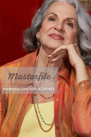 Close-up of a senior woman smiling with her hand on her chin