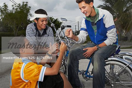 Teenage boy gesturing to his two friends and smiling