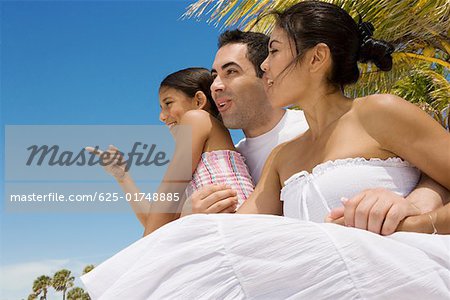 Mid adult couple smiling with their daughter