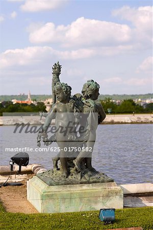 Statues near a pond in a formal garden, Palace of Versailles, Versailles, France