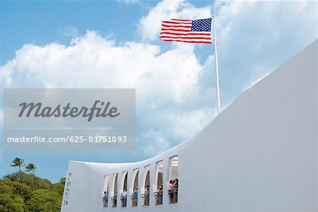 Low angle view of an American flag fluttering on a memorial building, USS Arizona Memorial, Pearl Harbor, Honolulu, Oahu,
