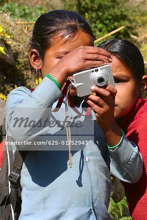 Close-up of two girls taking a photograph of themselves, Tadapani, Annapurna Range, Himalayas, Nepal