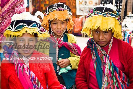 Portrait of three girls in a market, Pisaq, Urubamba Valley, Peru