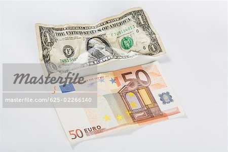 Close-up of a US dollar bill and fifty euro banknote