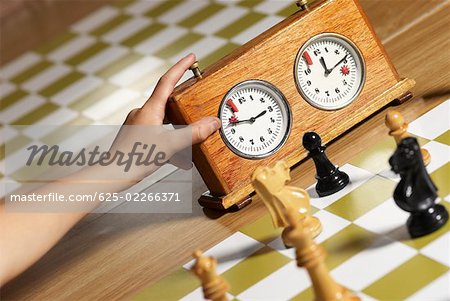 Close-up of a human hand pushing button of a chess clock