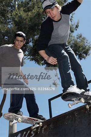 Low angle view of two young men skateboarding