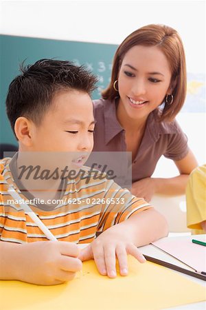 Female teacher teaching her student in a classroom