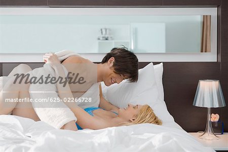 Side profile of a couple romancing on the bed