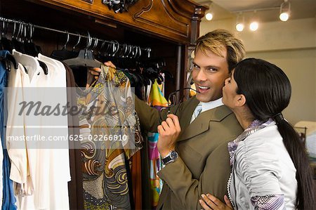 Young woman kissing a mid adult man in a clothing store