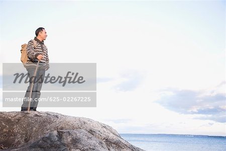 Mature man standing on a rock at the seaside