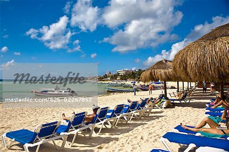 Tourist lying on lounge chairs on the beach, Playa Del Carmen, Quintana Roo, Mexico