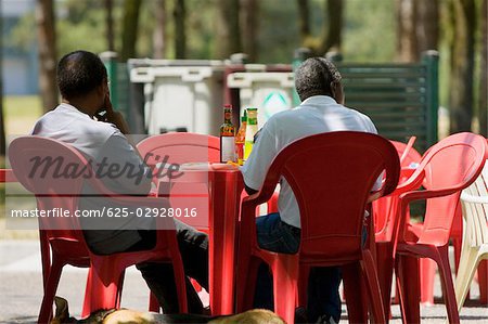 Rear view of two men sitting at a sidewalk cafe, Bordeaux, Aquitaine, France