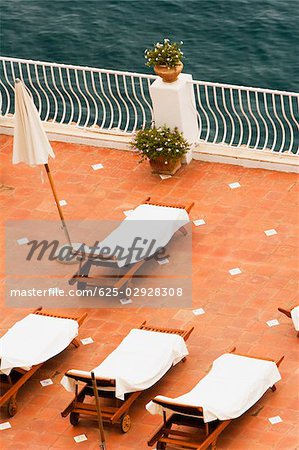 High angle view of empty lounge chairs with a patio umbrella, Positano, Amalfi Coast, Salerno, Campania, Italy