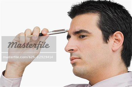 Close-up of a businessman holding a pen and thinking