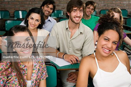 Portrait of university students sitting in a classroom and smiling