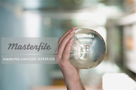 Close-up of a person's hand holding a crystal ball