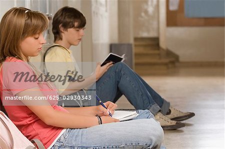 Side profile of a teenage girl and a teenage boy studying
