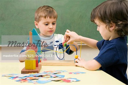Two boys playing with a buzz wire game